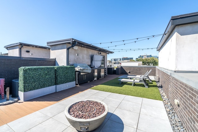 view of patio / terrace featuring a fire pit, a wooden deck, and grilling area