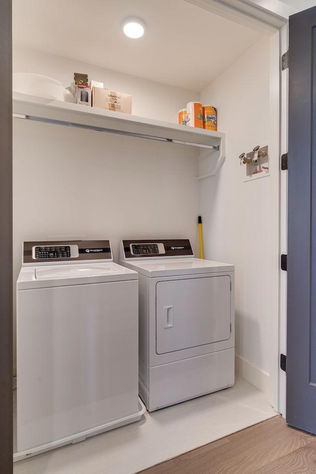 laundry area with light wood-type flooring and separate washer and dryer