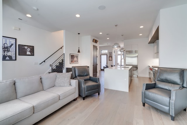 living room with light wood-type flooring and sink