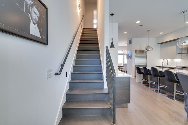 stairs featuring sink and hardwood / wood-style floors