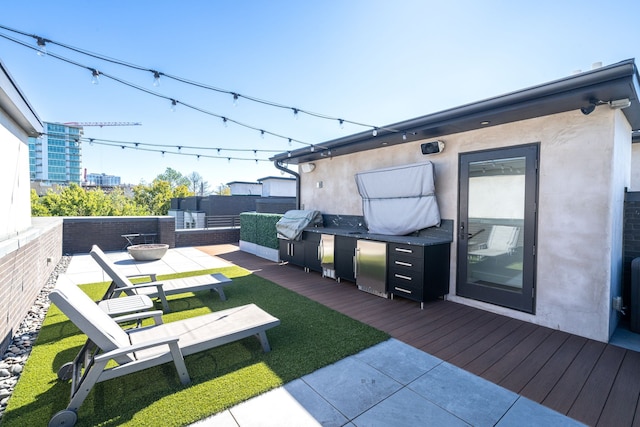 wooden terrace featuring an outdoor kitchen and grilling area