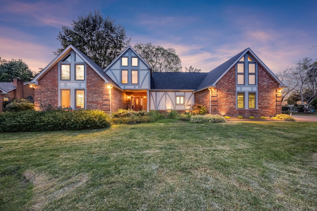 tudor home featuring a yard