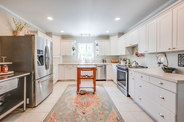 kitchen with stainless steel appliances, white cabinetry, sink, light tile patterned floors, and crown molding