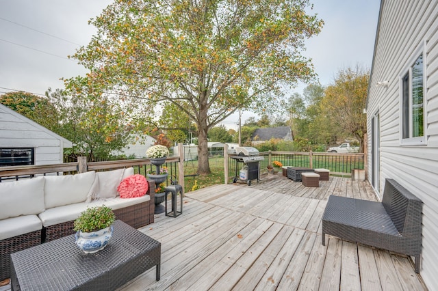 wooden deck with an outdoor hangout area and grilling area