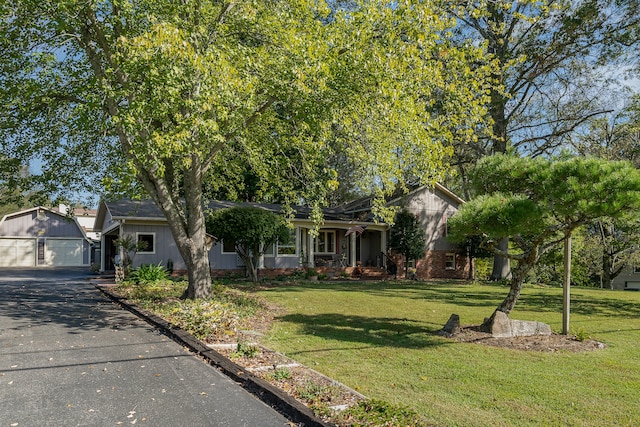 view of front of property with a garage, a front yard, and an outdoor structure