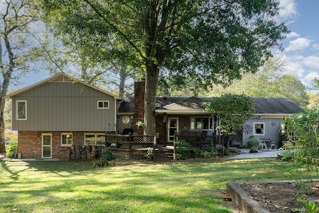 rear view of house featuring a deck and a yard