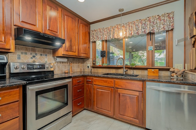 kitchen featuring dark stone countertops, stainless steel appliances, crown molding, and sink