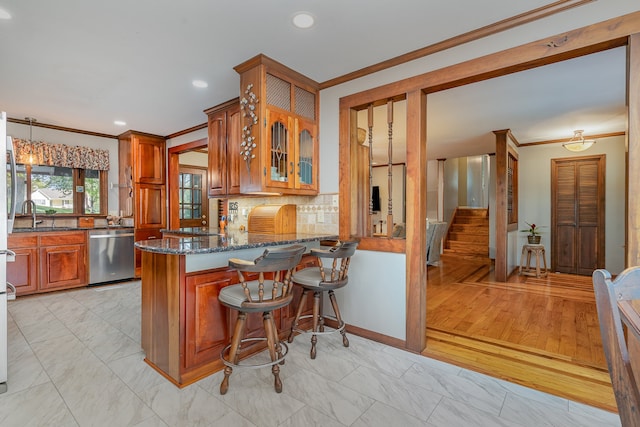 kitchen featuring light wood-type flooring, crown molding, dark stone countertops, dishwasher, and kitchen peninsula