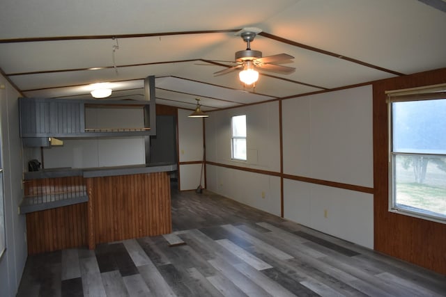 kitchen with kitchen peninsula, ceiling fan, dark wood-type flooring, and lofted ceiling