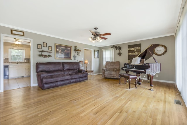 living room featuring light hardwood / wood-style floors, crown molding, and sink