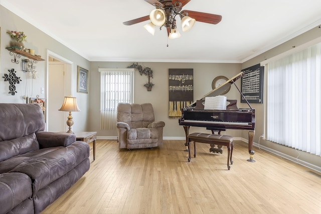 living area with crown molding, light hardwood / wood-style flooring, and ceiling fan