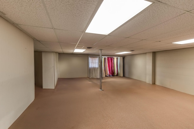 basement featuring a drop ceiling and light carpet