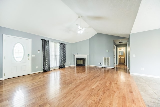 unfurnished living room with lofted ceiling, light hardwood / wood-style floors, and ceiling fan