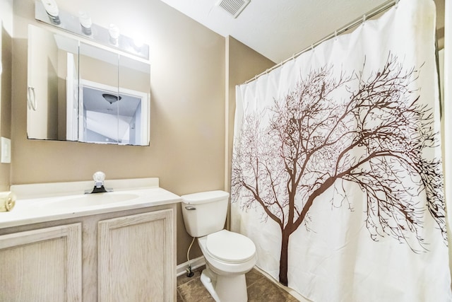 bathroom featuring vanity, tile patterned flooring, and toilet