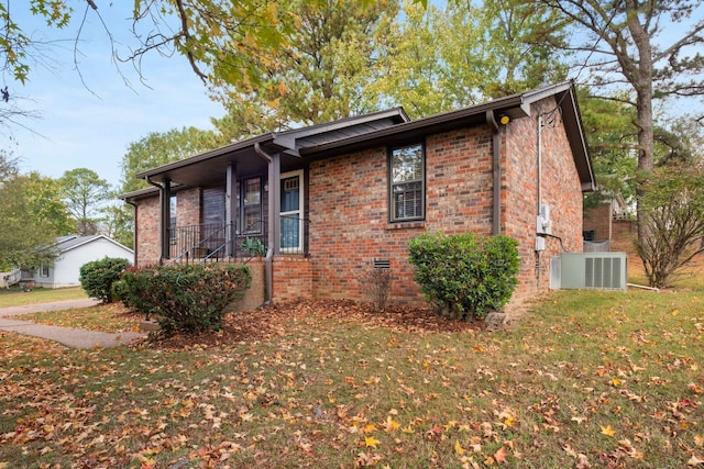 view of property exterior with a lawn and central AC