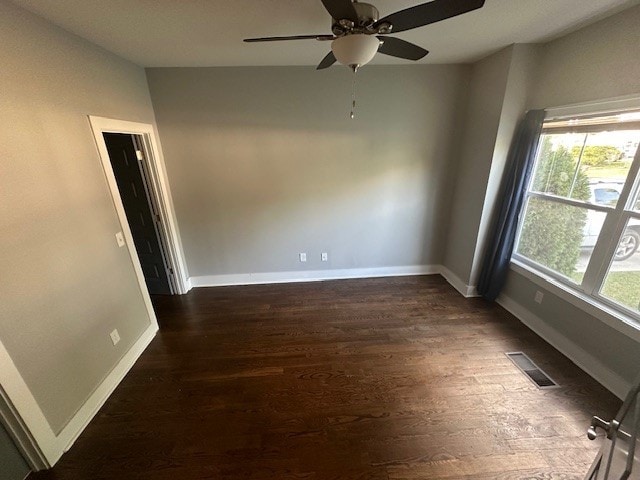 unfurnished room featuring ceiling fan and dark wood-type flooring