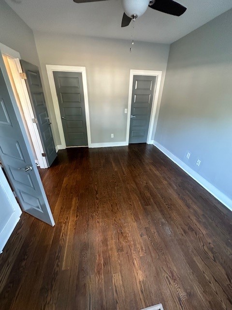 interior space with ceiling fan and dark wood-type flooring