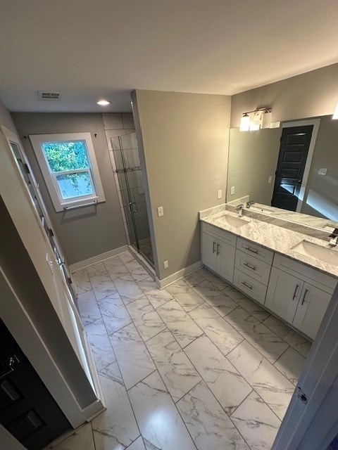 bathroom featuring a shower with door and vanity