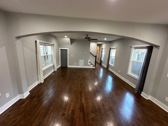 unfurnished living room featuring ceiling fan and dark hardwood / wood-style floors