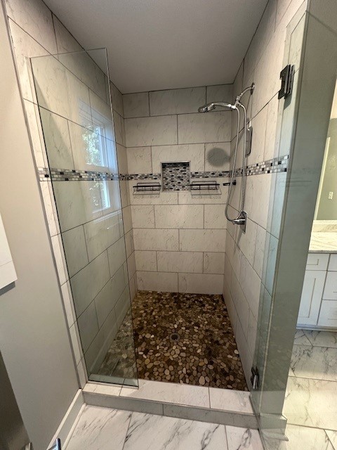 bathroom featuring walk in shower and vanity