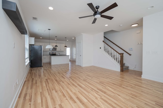 unfurnished living room featuring light hardwood / wood-style flooring and ceiling fan