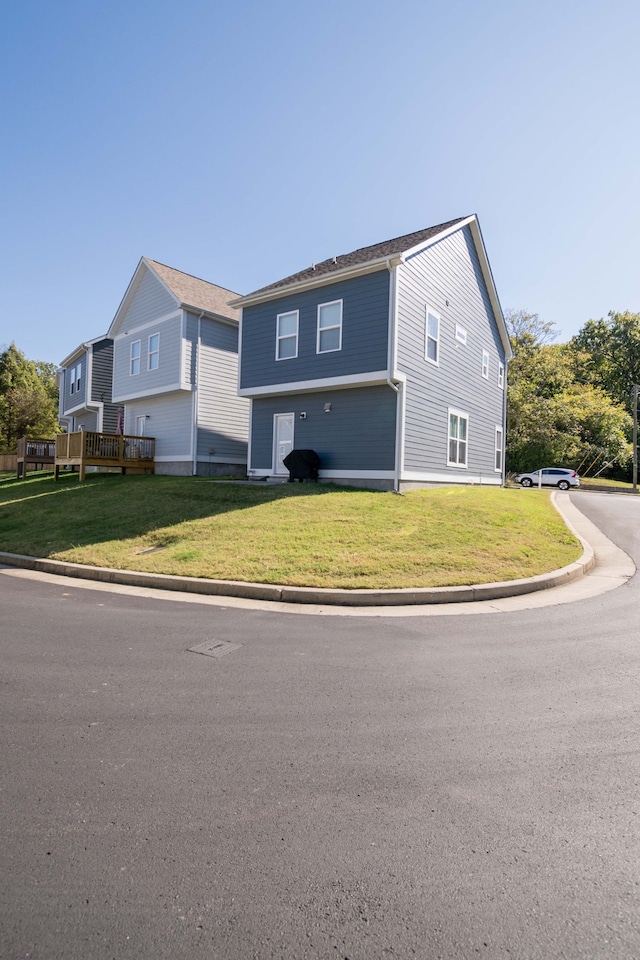 view of side of home featuring a wooden deck and a lawn