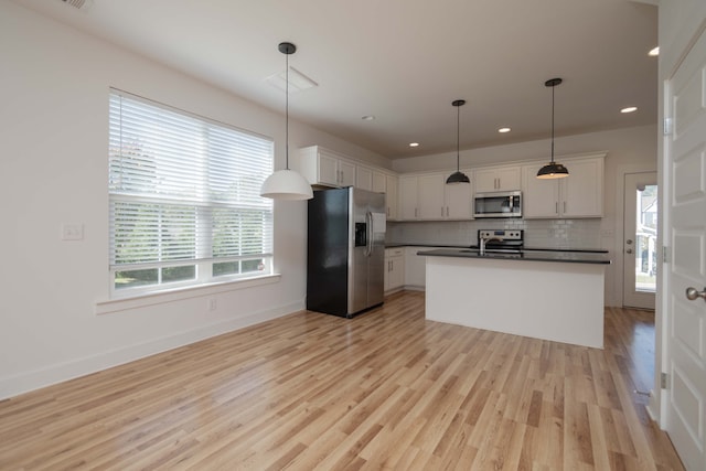 kitchen featuring white cabinetry, stainless steel appliances, and decorative light fixtures