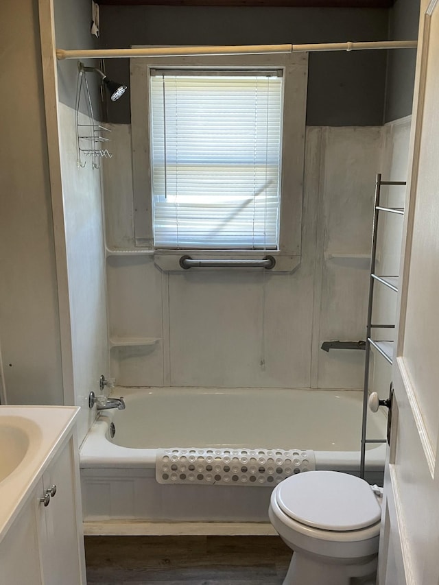 bathroom featuring toilet, wood finished floors, vanity, and shower / tub combination
