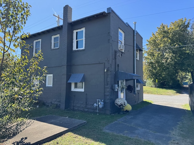 rear view of property with concrete block siding and a chimney