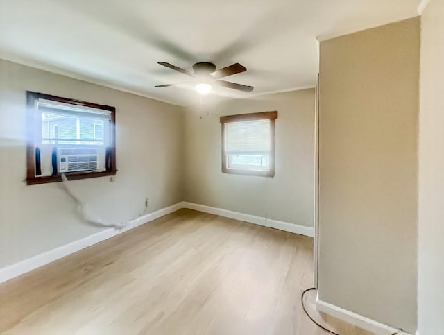 empty room featuring light wood-style flooring, a ceiling fan, plenty of natural light, and baseboards
