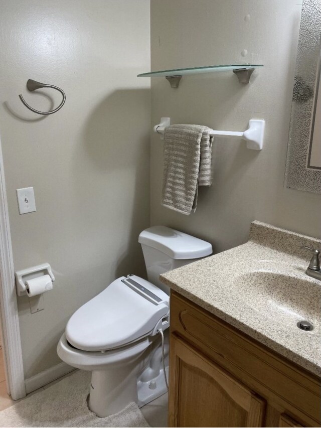 bathroom featuring tile patterned floors, vanity, and toilet