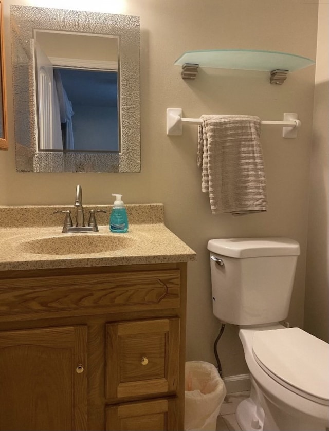 bathroom featuring tile patterned flooring, vanity, and toilet