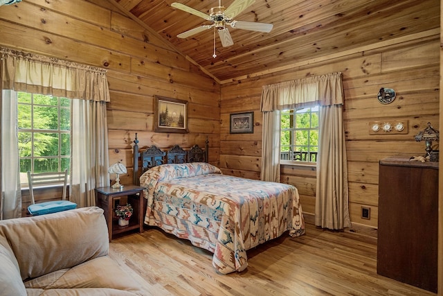 bedroom featuring vaulted ceiling, light hardwood / wood-style flooring, wood ceiling, and wood walls