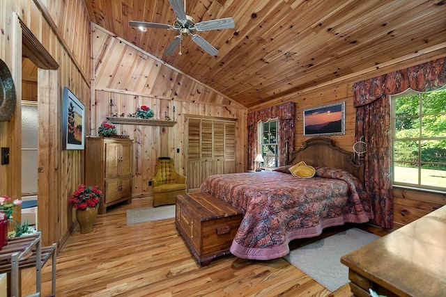 bedroom featuring a closet, light hardwood / wood-style floors, and wood walls