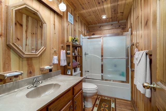 full bathroom featuring shower / bath combination with glass door, toilet, wooden ceiling, wooden walls, and vanity