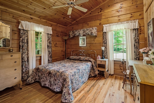 bedroom with lofted ceiling, ceiling fan, wooden ceiling, light hardwood / wood-style flooring, and wooden walls