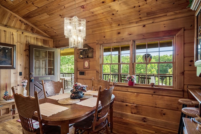 dining space featuring wood ceiling, hardwood / wood-style flooring, vaulted ceiling, wood walls, and a notable chandelier