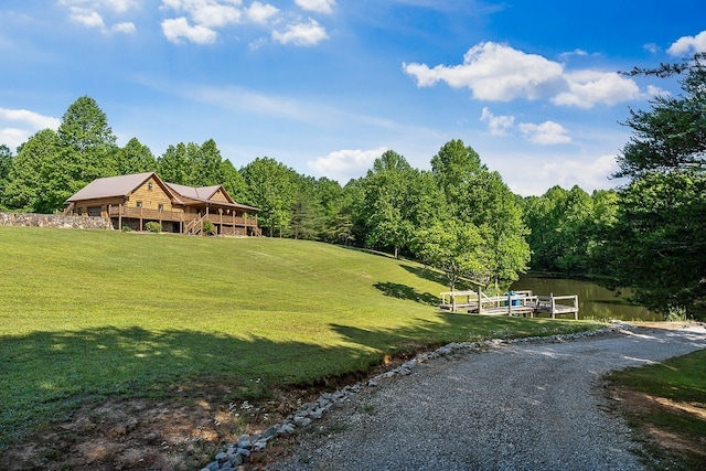 view of property's community with a lawn and a water view