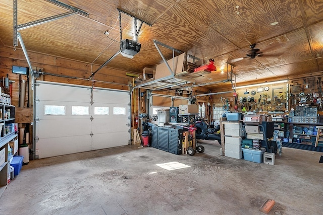 garage featuring a garage door opener, a workshop area, and ceiling fan