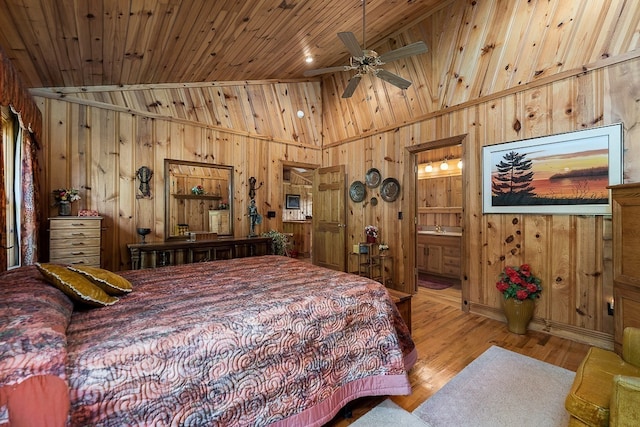 bedroom featuring connected bathroom, wooden walls, wooden ceiling, light wood-type flooring, and high vaulted ceiling