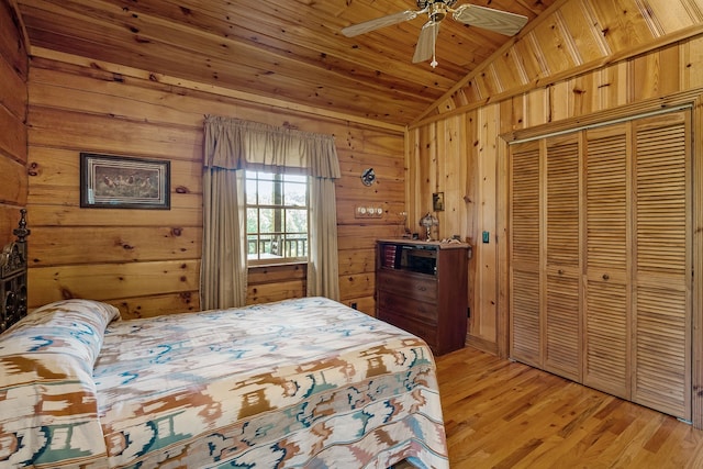 bedroom featuring lofted ceiling, ceiling fan, wooden ceiling, light wood-type flooring, and wooden walls