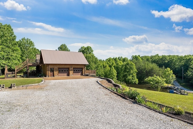 log cabin with a wooden deck, a front lawn, and a garage