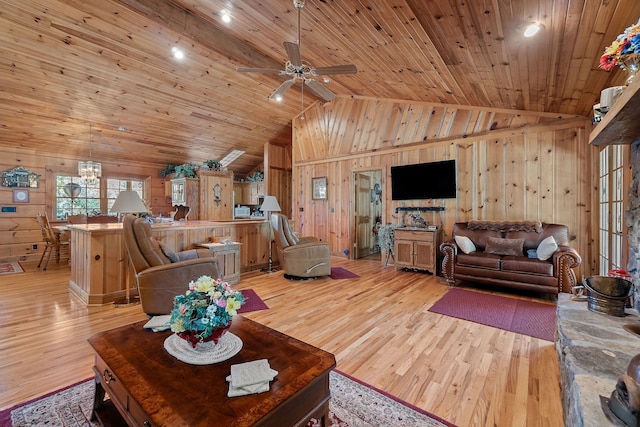 living room featuring ceiling fan with notable chandelier, light hardwood / wood-style floors, wooden ceiling, wooden walls, and high vaulted ceiling