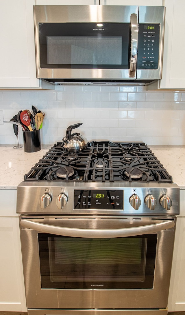 kitchen featuring light stone countertops, white cabinets, and appliances with stainless steel finishes