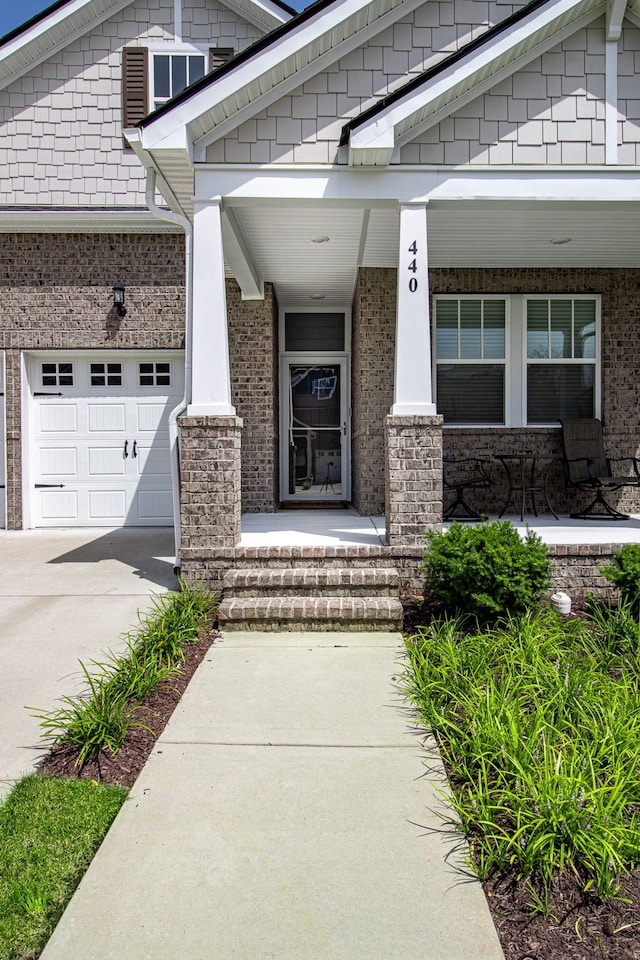 property entrance with covered porch and a garage