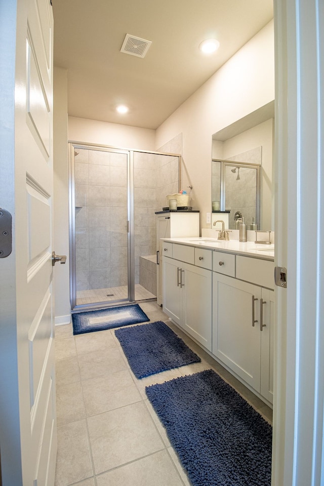 bathroom featuring tile patterned floors, vanity, and a shower with shower door