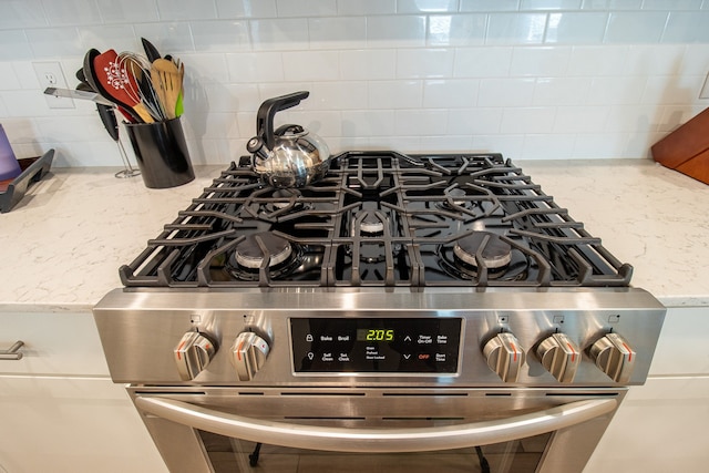 details with light stone countertops and stainless steel gas range oven