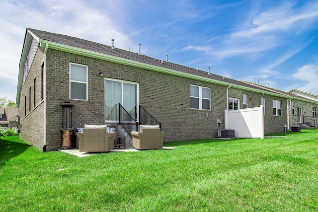 back of house featuring a lawn, a patio area, and central AC