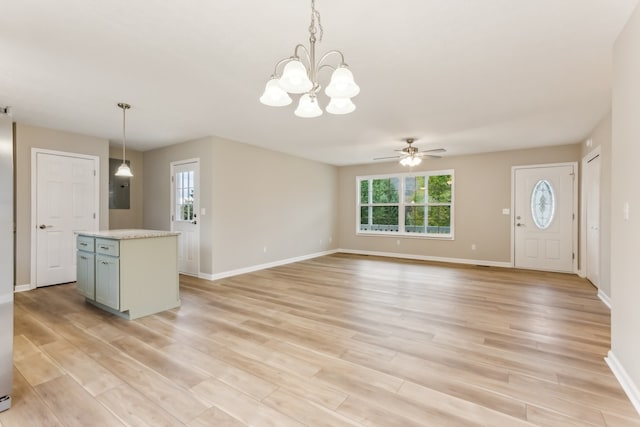 kitchen featuring hanging light fixtures, ceiling fan with notable chandelier, light hardwood / wood-style flooring, and a center island