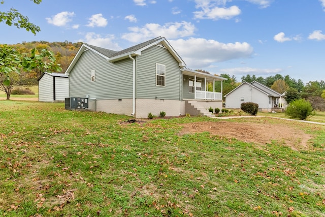 view of side of property featuring a lawn and covered porch